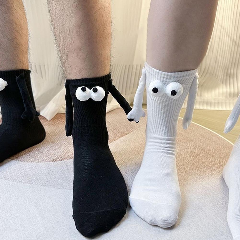 A male wearing black 3D magnetic attraction socks is standing next to a woman wearing white 3d magnetic attraction socks. The socks are holding hands. It is adorable in our opinion.